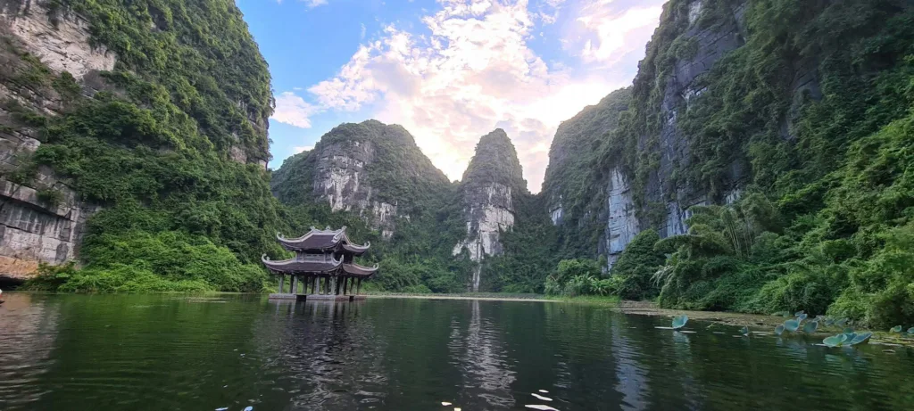 Bến thuyền gỗ bên mặt nước và núi rừng Tràng An