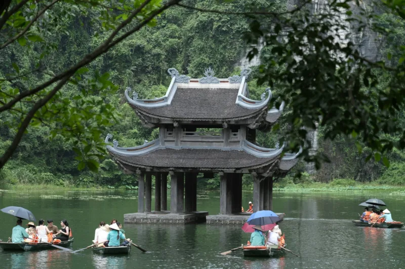 Du khách đi thuyền trên sông giữa núi đá vôi ở Tràng An, Ninh Bình